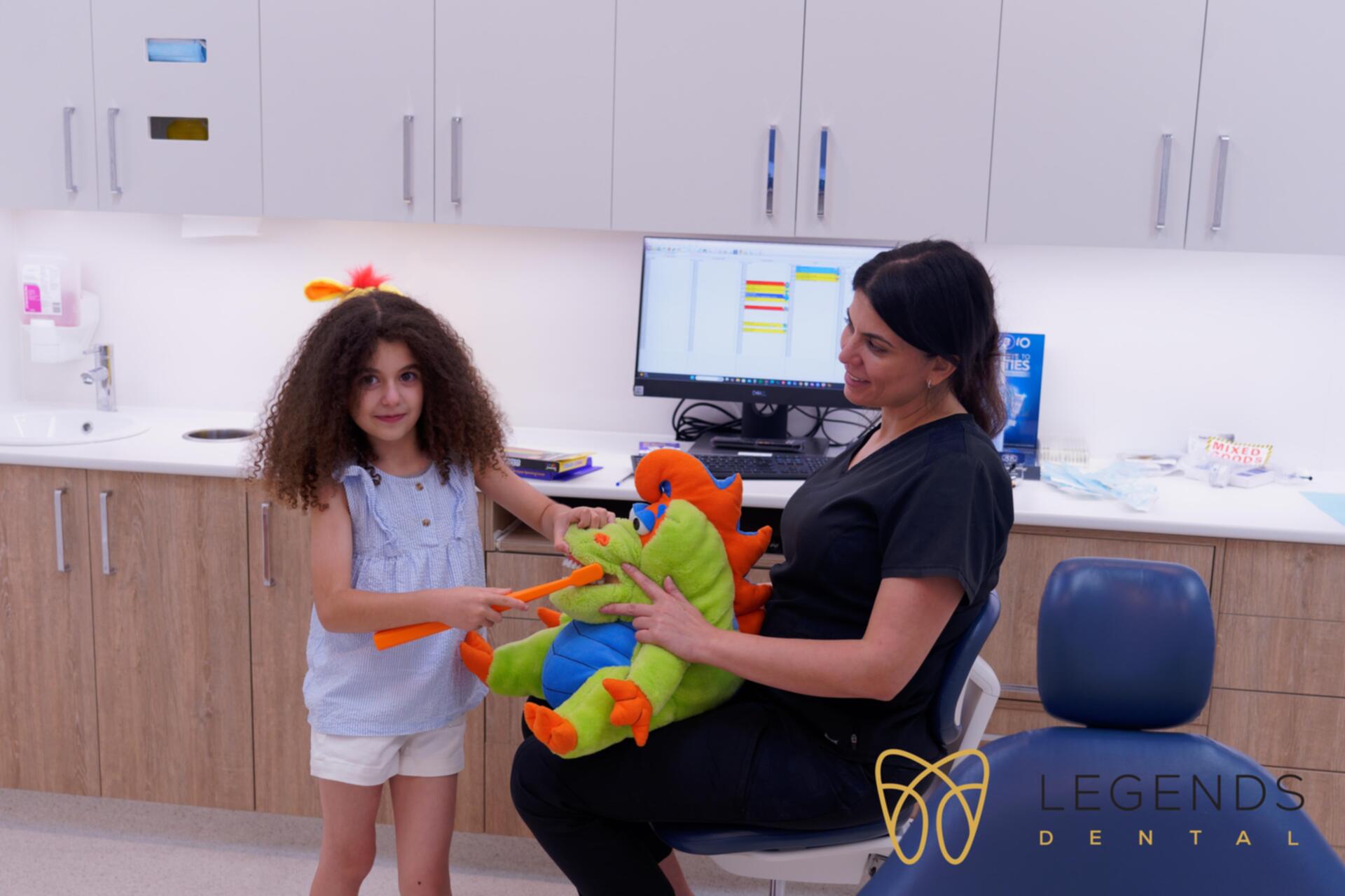 Dr Rouba educating a child with a dragon plush