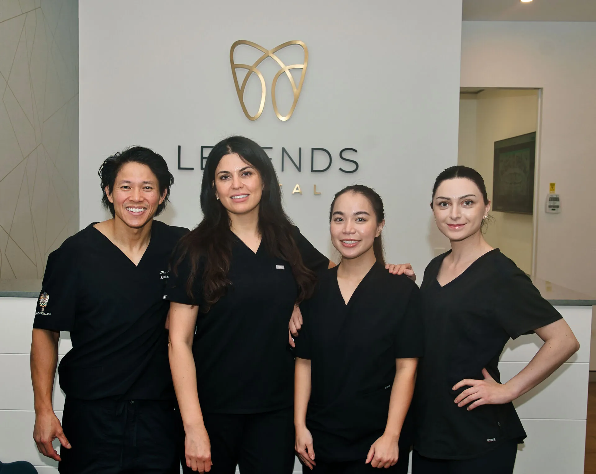 Legends Dental Team in front of clinic wall